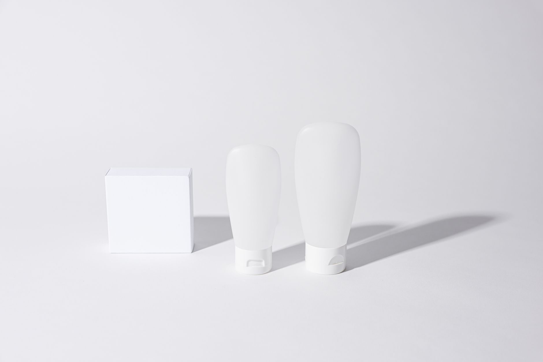White packaging shapes on a pale background